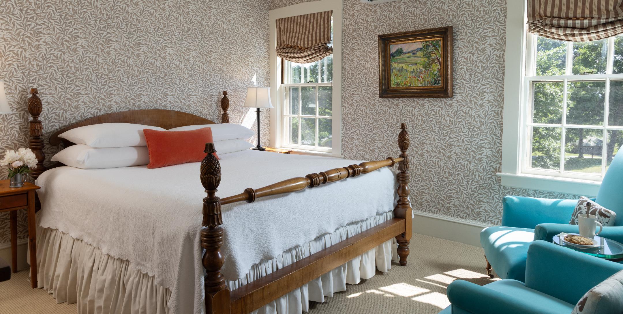 Plush bed, chest of drawers, and flowers in Brown Room at The Inn at Castle Hill