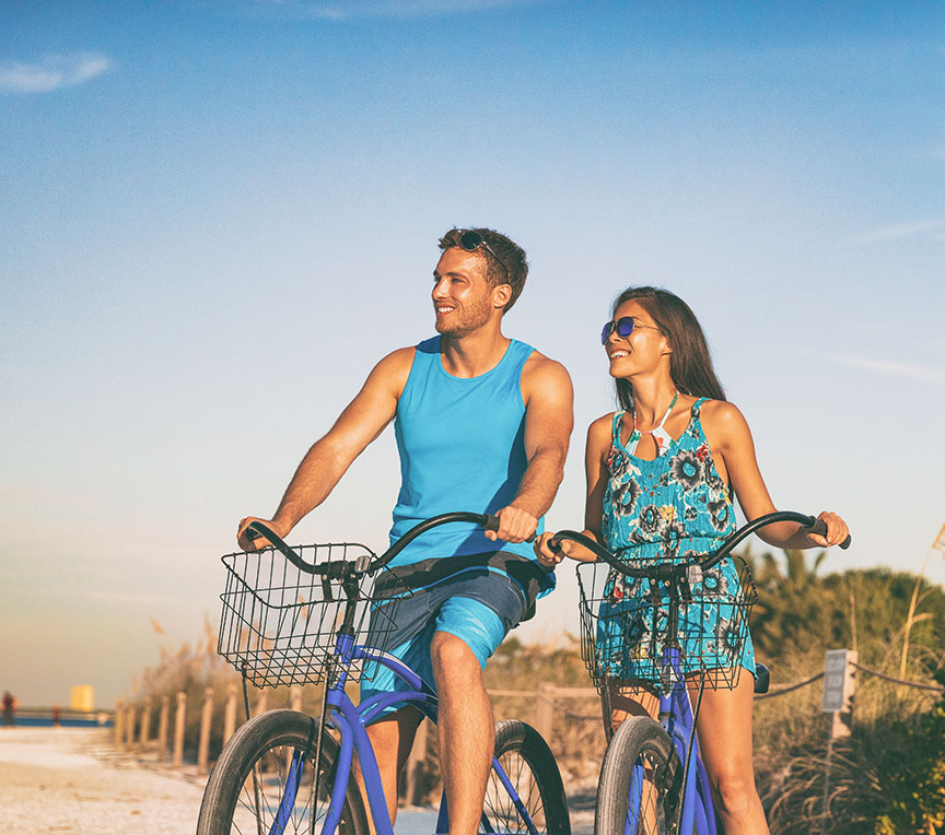 Couple riding bike to the beach
