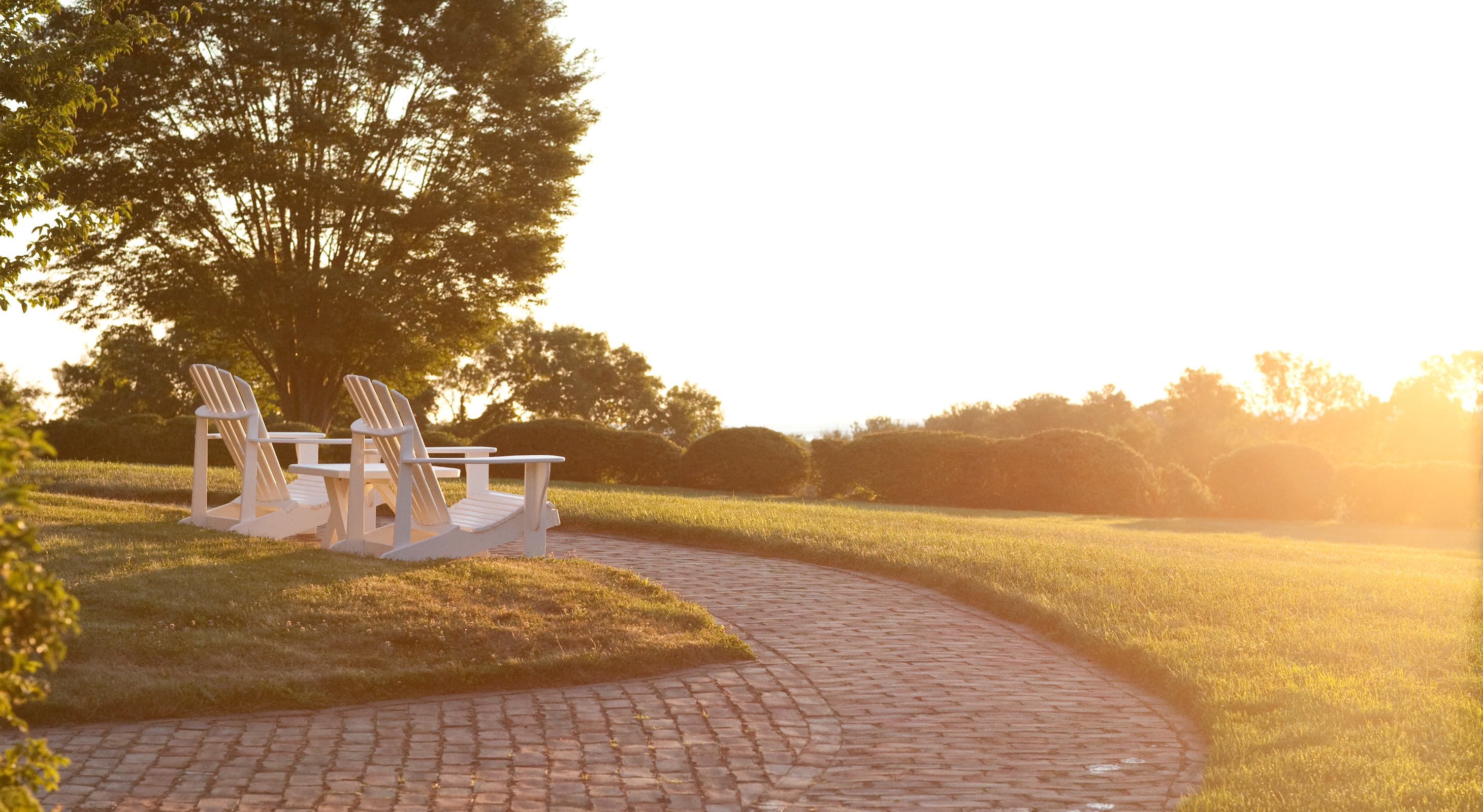 Adirondack chairs in the lawn and a view of the coast at wedding venue accommodations in Ipswich